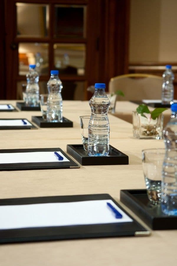 Bottled water set beside notepads along a boardroom table